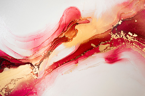 Luxury abstract fluid art painting in alcohol ink technique, mixture of red, yellow and gold paints. Imitation of marble stone cut, glowing golden circles. Tender and dreamy design.