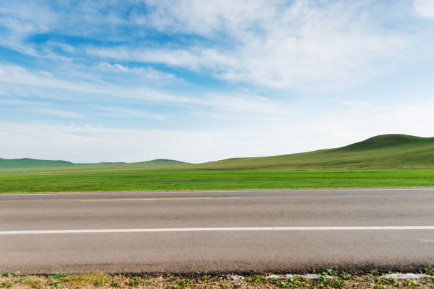 istock Empty asphalt road and green field 1346674419