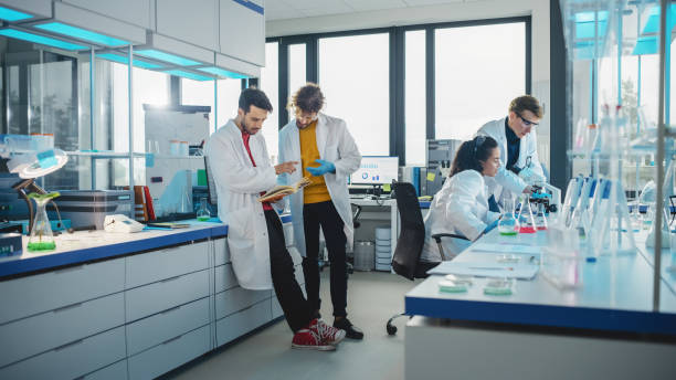 istock Modern Medicine Laboratory: Diverse Team of Multi-Ethnic Young Scientists Analysing Test Samples. Advanced Lab with High-Tech Equipment, Microbiology Researchers Design, Develop Drugs, Doing Research 1346675608