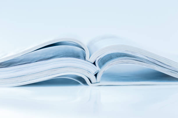 istock Stack of open magazines in blue tone on white background 1346675677