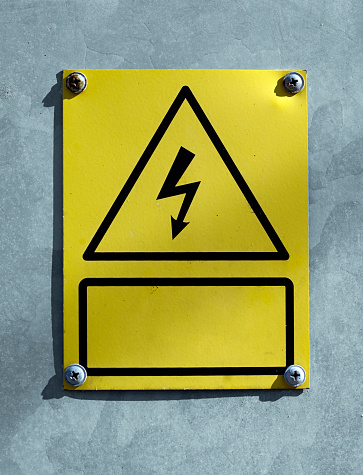 Yellow sign warning high voltage danger to life on electrical box with German text