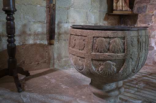 Caceres, Spain - Jan 14th, 2021: Baptismal font of Church of Santiago, early site of the Military Order of the Knights of Santiago. Caceres, Extremadura, Spain