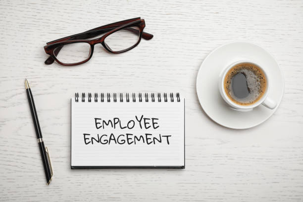 istock Notebook with text EMPLOYEE ENGAGEMENT, glasses and cup of coffee on table, flat lay 1346680087