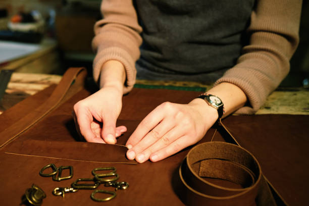 istock young brunette woman works in a bag making studio, cuts out details 1346680167