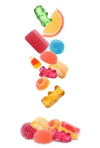 Set of different jelly candies falling into pile on white background
