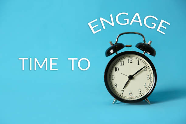 istock Alarm clock and phrase TIME TO ENGAGE on light blue background 1346680481