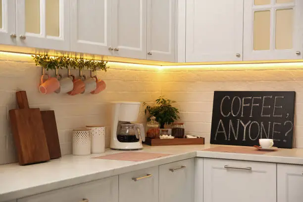 Stylish kitchen interior with modern coffeemaker on countertop