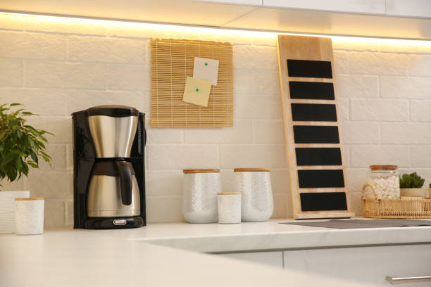 istock Modern coffeemaker on countertop near brick wall in kitchen 1346681238