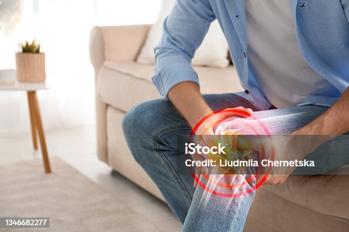istock Man suffering from knee pain at home, closeup 1346682277