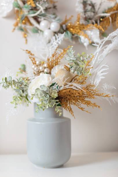 istock Christmas interior decoration. Winter bouquet in vase on white table. 1346683064