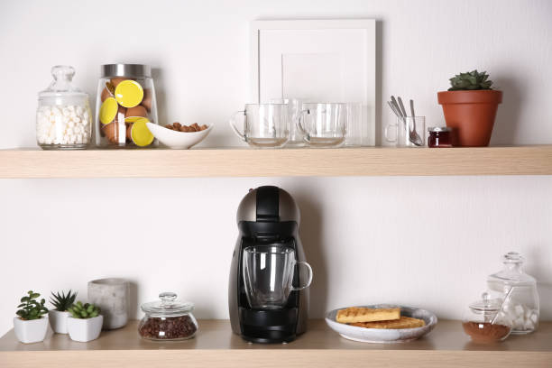 istock Modern coffeemaker on wooden table near white wall 1346684050