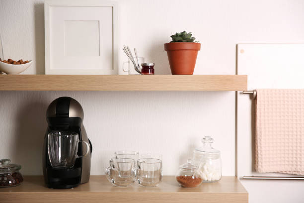 istock Modern coffeemaker on wooden table near white wall 1346684052