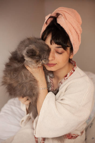 istock Beautiful young woman playing with her cat at home 1346684251