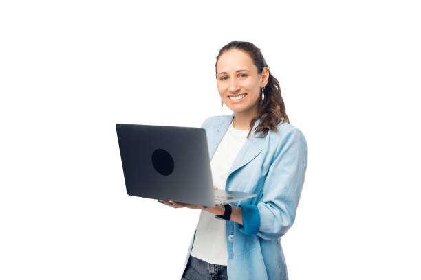 istock Pretty woman is holding an opened laptop while smiling at the camera. 1346686601