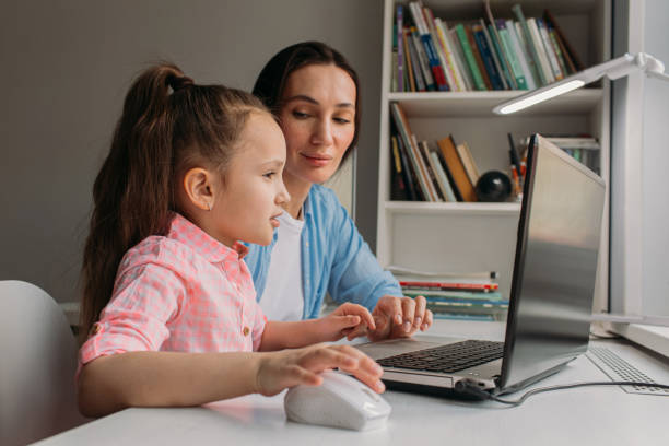istock mom helps daughter do homework remotely on laptop 1346686603