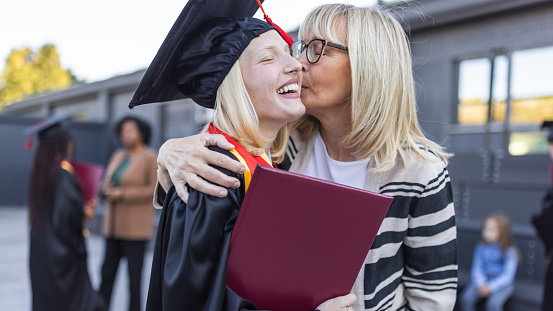 Graduation. Mother congratulating graduating daughter