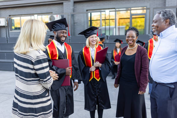 istock Mixed - race couple on graduation ceremony 1346686962