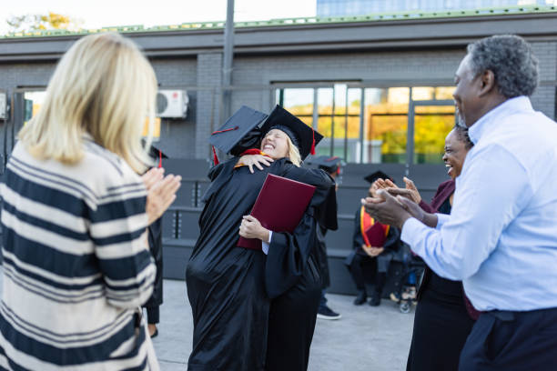 istock Mixed - race couple on graduation ceremony 1346686972