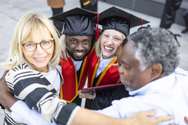 istock Mixed - race couple on graduation ceremony 1346686995