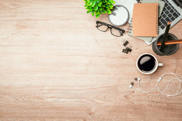 istock Work from home. desk office with laptop, blank notepad, coffee cup and pen on wood table. Flat lay top view copy spce. 1346687773
