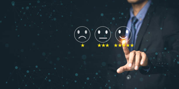 istock Customer Service and Satisfaction Concept Businessmen touch the virtual screen on happy smiley icons to achieve service satisfaction and feedback with excellent rated reviews. 1346688026