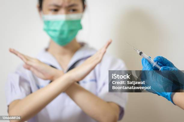 Hands Of Doctor Preparing A Syringe For Injection To Prevent Coronavirusteenage Girl With Crossing Hands Gestureasian Student Show Distrustrefusing Vaccinedangers Or Side Effects After Vaccination Stock Photo - Download Image Now