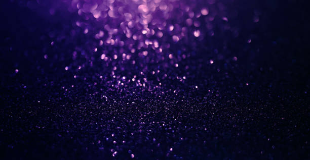 istock Abstract background of purple glitter lights and black. 1346690168