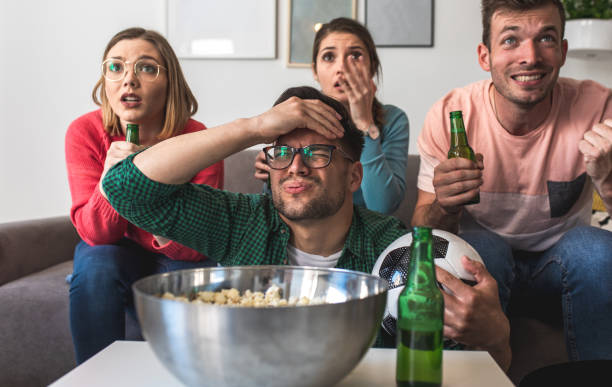 istock Cheerful friends watching soccer match at home and cheering for their team. 1346690708
