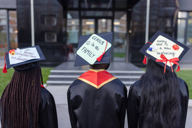 istock Students after graduation ceremony with creative messages on the mortarboard 1346690763
