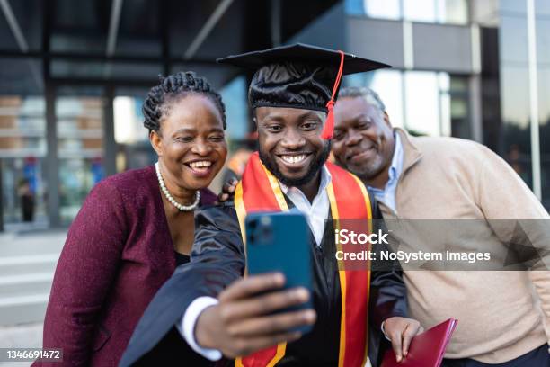 Excited African American College Graduate With His Family After The Graduation Ceremony Stock Photo - Download Image Now