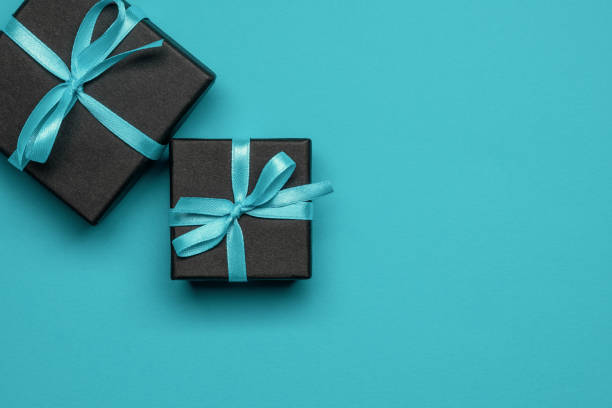 istock Black gift boxes tied with turquoise ribbons on a turquoise background. 1346691742