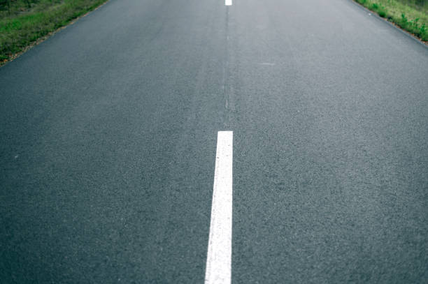 Close up of new asphalt road with lines in nature. Close up of asphalt road with lines in nature. pavement ends sign stock pictures, royalty-free photos & images