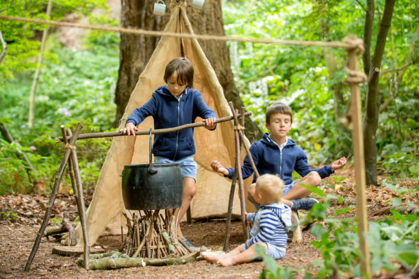 Beautiful children, siblings, camping in the forest, fireplace and tent