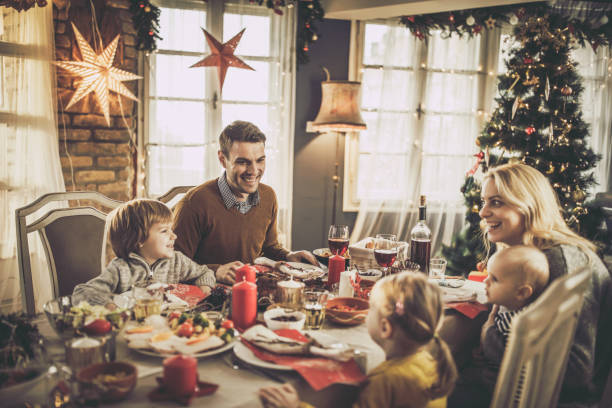 istock Young happy family enjoying during New Year's dinner at dining table. 1346693946