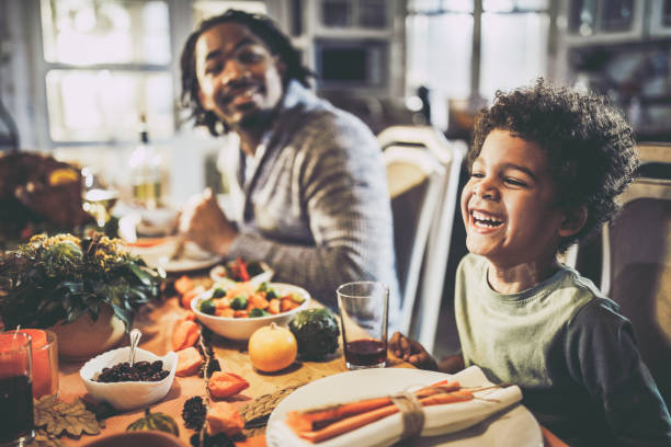 istock Happy black boy having a meal with his father at dining table. 1346694628