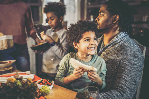istock Happy black boy with his father at dining table. 1346695318