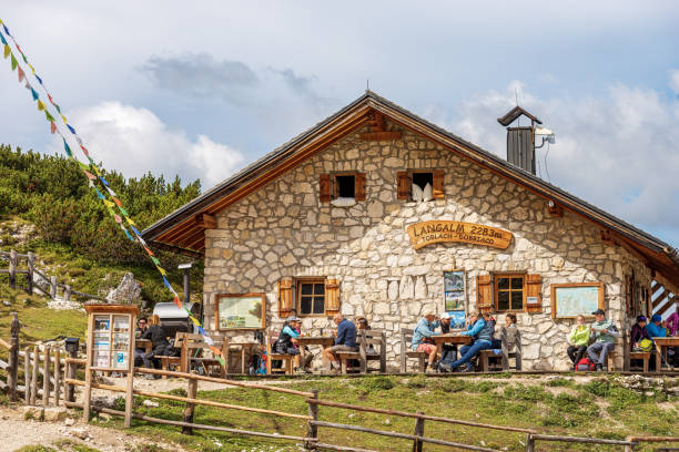 Alpine Mountain Hut Malga Grava Longa or Langalm Hutte - Tre Cime di Lavaredo Dobbiaco, Italy - Sept 7, 2021: Alpine mountain hut called Malga Grava Longa or Langalm Hutte, 2283 m., in front of Tre Cime di Lavaredo or Drei Zinnen (three peaks of Lavaredo), Dolomiti di Sesto Natural Park, Dobbiaco or Toblach, Trentino Alto Adige, Italy, Europe. A large number of hikers have lunch outside the hut on a sunny summer day. trentino south tyrol stock pictures, royalty-free photos & images