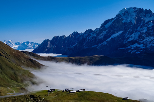 A spectacular series of 5 images recording an especially early incidence of Temperature Inversion in the Grindelwald Valley of the Bernese Oberland in Switzerland, October 2021. Such meteorological events are more common in the depths of winter than early autumn, making these images unique. The extreme, acute angle of the light at this time of year makes these images stand out from the crowd. They are all taken from Grindelwald First (2166m/7009ft) which is reached by one of the world's longest Gondola Cable Cars in the world. he cloud top on this October day in 2021 was at around 6000ft with the base at ground level, closer sea level but not at zero. Temperature inversion results in warm air sitting on top of cold air and keeping the cloud hanging in valleys when in mountainous areas. In these images only the very tallest peaks of the Bernese Oberland can be seen to emerge. The two Alpine massifs clearly visible are (1) in the Haslital Region, specifically Mount Titlis and its surrounding peaks (Images 1 & 4) and in the Jungfrau Region, specifically the Eiger, Monch and Jungfrau (Images 2, 3 & 5). Specifically each image is as follows:
Image 1: The Wetterhorn and Schwarzwald Alp receding to the peaks of Haslital (Mts. Titlis and Alpentower) in the distance.