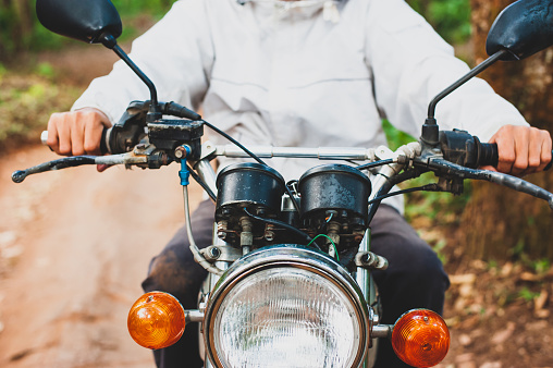 Close up of a young man riding a motorcycle. The concept of safety and proper motorcycling.