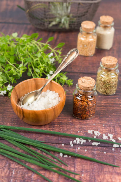 istock Spices in small bottles, salt, basil and chives on a wooden table 1346706780