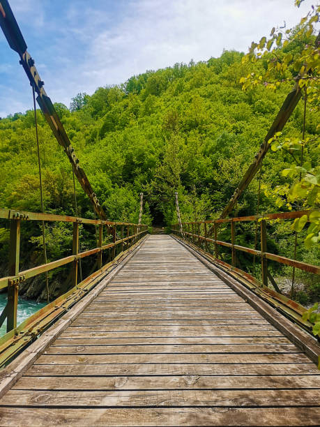 istock Wooden bridge leads to black hole 1346707451