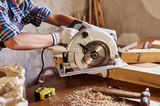 istock Skilled female carpenter using a circular saw. Woman worker in the carpenter workroom renovation. Small business concept 1346708868