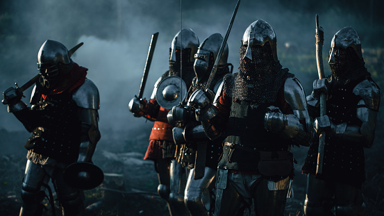 Epic Invading Army of Medieval Soldiers Marching Through Forest. Armored Warriors with Swords on a Kill and Destroy Mission. War, Battle, Invasion, Conquest. Cinematic Historical Reenactment