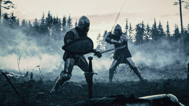 Dark Age Battlefield: Two Armored Medieval Knights Fighting with Swords. Battle of Armed Warrior Soldiers, Killing Enemy in Mysterious Forest. Cinematic Smoke, Mist, Light in Historic Reenactment Dark Age Battlefield: Two Armored Medieval Knights Fighting with Swords. Battle of Armed Warrior Soldiers, Killing Enemy in Mysterious Forest. Cinematic Smoke, Mist, Light in Historic Reenactment dueling stock pictures, royalty-free photos & images