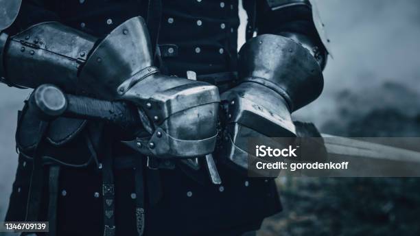 Medieval Knight Wearing Armour And Helmet Draws Sword From Shearh Ready To Fight Kill His Enemy In Battle Warrior Soldier On Battlefield War Invasion Crusade Cinematic Historic Reenactment Stock Photo - Download Image Now