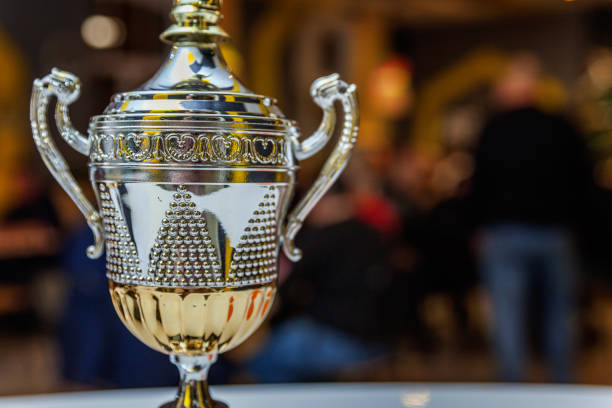 Winner or champion gold trophy cup with abstract dark blurred background. Victory first place of competition. Winning or success concept