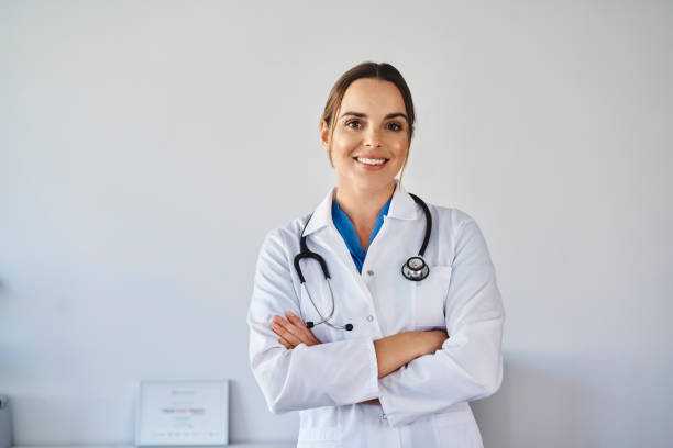 Portrait of smiling female doctor wearing uniform standing Portrait of smiling female doctor wearing uniform standing female doctor photos stock pictures, royalty-free photos & images
