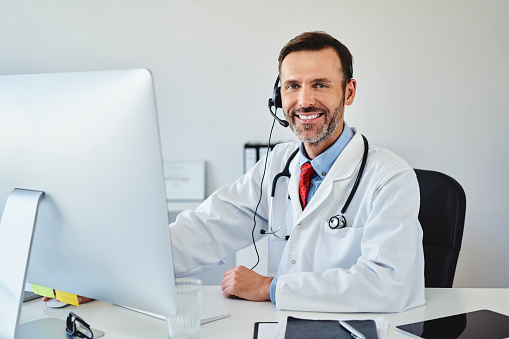 Male doctor working on computer as online consultant