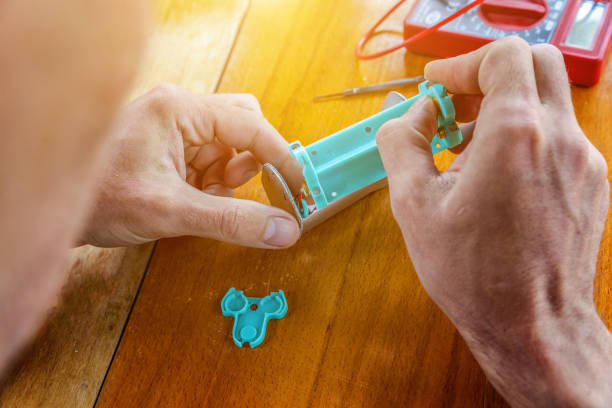 istock Man hands fixing modern vaporizer e-cig gadget to vape e-liquid. Maintenance of electronic equipment mech mod vaping device. Vaper device repair service 1346711351
