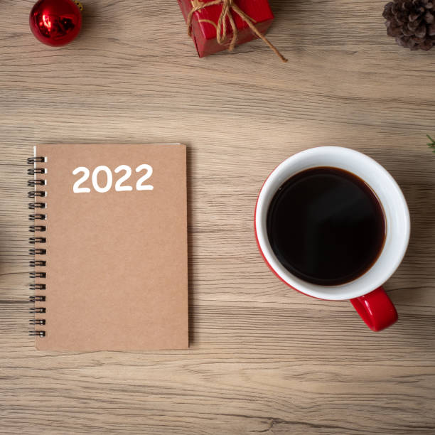 istock 2022 notebook, black coffee cup and Christmas gift on wood table, Top view and copy space. Xmas, Happy New Year, Goals, Resolution, To do list, Strategy and Plan concept 1346712545